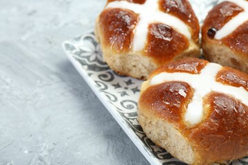 Tasty hot cross buns on gray textured table, closeup. Space for text