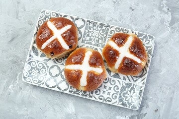 Tasty hot cross buns on gray textured table, top view