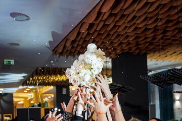 Crowd throws flowers at event, creating a colorful spectacle in the room