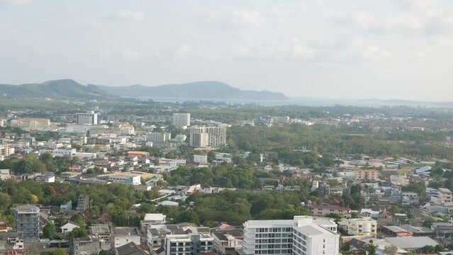 aerial view of phuket town city with background of bay and beach and mountain hill range under sunny sunshine sky daytime