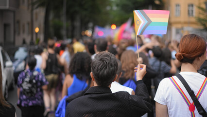 Many lesbian people wave rainbow flag. Crowd walk city street. Fun lgbt community symbol. Stop no...