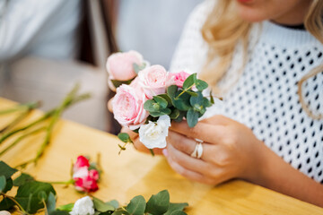 Obraz na płótnie Canvas A woman happily arranging a bouquet of roses at a wedding ceremony