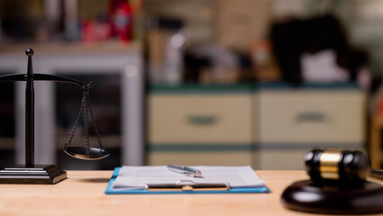 A scale is on a table with a piece of paper and a gavel