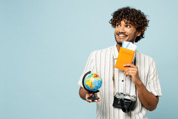 Traveler fun Indian man wear white casual clothes hold passport ticket, globe isolated on plain...