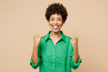 Young woman of African American ethnicity wear green shirt casual clothes do winner gesture...