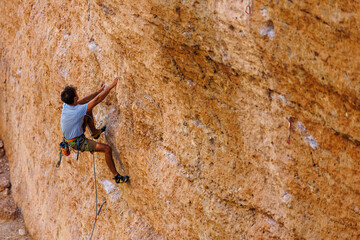 climber climbs the wall. a man is engaged in sport climbing. - 781905948
