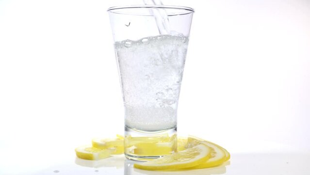 Lemon Fruits with pouring sparkling Water in a Glass
