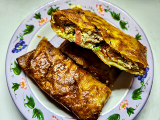 Beef egg martabak, which contains beef, tomatoes, sausage and vegetables