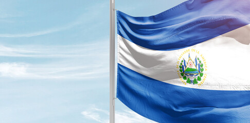 El Salvador national flag with mast at light blue sky.