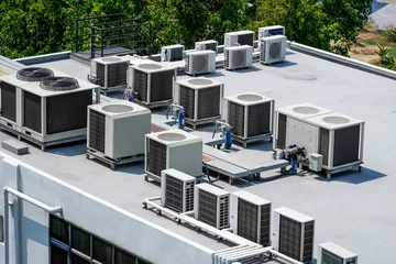 Fotobehang The external units of the commercial air conditioning and ventilation systems are installed on the roof of an industrial building. © aapsky
