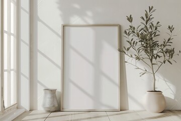 An empty picture frame sits next to a lush potted plant, creating a contrast between the man-made and natural elements.