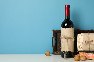 Matzo, nuts, bottle of wine and Torah on blue background, space for text