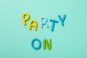 The word "party" is made of colored plasticine on a turquoise background.