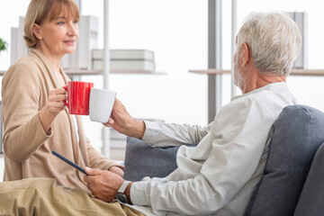 Senior couple spending time together in the living room, Retired man and woman drinking coffee, and tea together, Happy family concepts