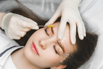 A cosmetologist applies permanent makeup to the eyebrows - eyebrow tattoo. eyebrow perm