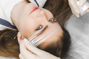 A cosmetologist applies permanent makeup to the eyebrows - eyebrow tattoo. eyebrow perm