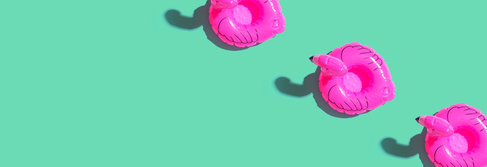 Summer concept with pink flamingo floats - flat lay