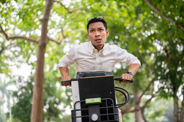 An anxious Asian businessman is in a hurry to get to work in the morning, riding a bike.