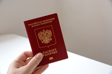 Close up of a female hand holding a Russian passport, blurry background