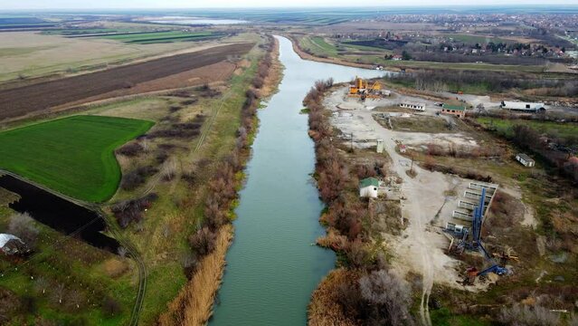 Drone flies over river Bega towards its confluence with canal DTD near town