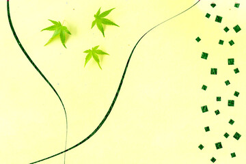 カエデの若葉と和紙の切り絵風デザイン（黄色の背景）