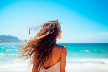 Naklejka premium A joyful young Caucasian woman with flowing hair, smiling on a sunny beach, embodying a sense of freedom and relaxation.