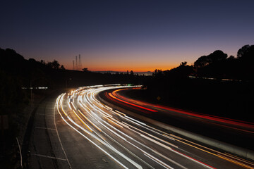View of light streaks created by traffic coming from San Francisco and Oakland at sunset, as seen...