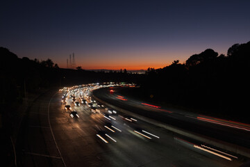 Countless cars stream along Highway 24 in Oakland at sunset, heading inland from San Francisco and...