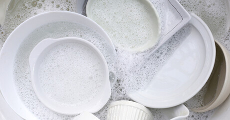Dish washing, Dirty dishes soaking in kitchen sink.