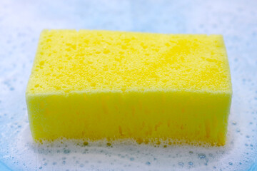 Cleaning sponge in foam of dishwashing liquid. Washing dishes concept