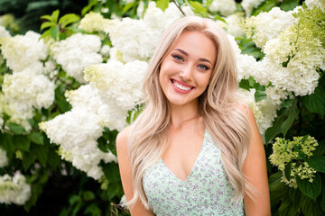 Charming nice cheerful lovely girlfriend in front of blooming flowers botanical garden enjoying fresh smell