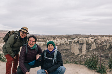 Portrait of adventurous family, two mothers and a teenage daughter hiking in cappadocia turkey