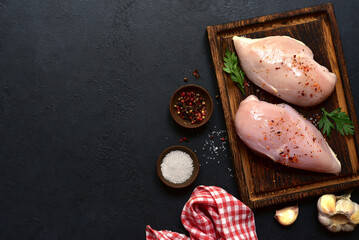 Raw chicken fillet or breasts with ingredients for cooking. Top view with copy space.