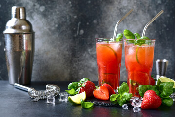 Cold summer strawberry cocktail with lime and basil in a  glasses .