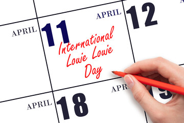 April 11. Hand writing text International Louie Louie Day on calendar date. Save the date.