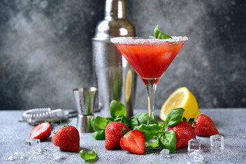 Cold summer strawberry cocktail with lemon and basil in a  martini  glasses .