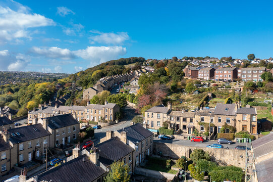 Aerial photo of the tow of Huddersfield in the Metropolitan Borough of Kirklees, West Yorkshire, England showing rows of terrace houses an homes in the Autumn time on a sunny day.