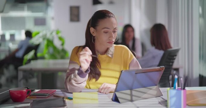 Indian Asian Hindu young adult sad busy girl sitting chair job office use tablet touch pad look cam gen z upset female woman lady staff do day work decline data feel bad show thumb down no hand sign