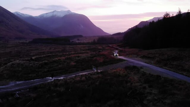 Aerial view of van driving on a road in Glen Etive at night in Highlands, Scotland