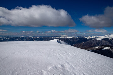Fototapeta premium on the top of the mountain in winter above the clouds
