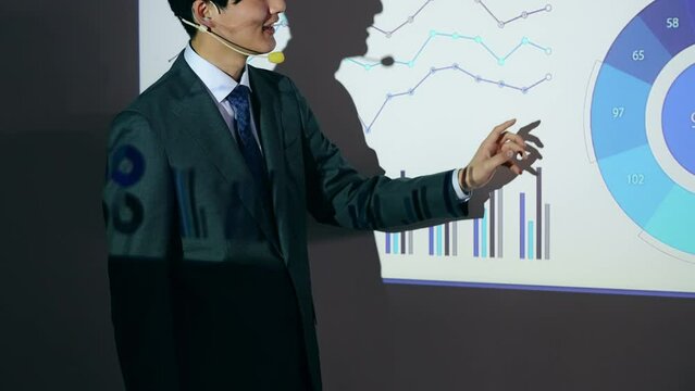 Asian man giving a presentation using a projector