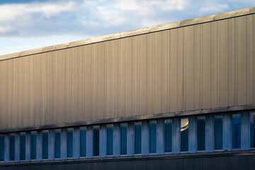 Closeup of a modern building in gray and blue colors against the sky
