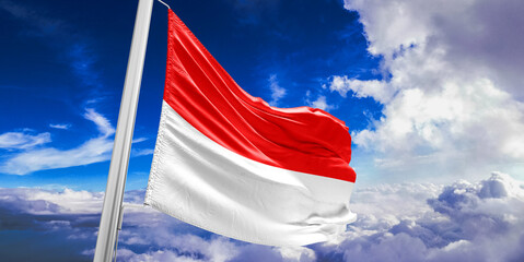Indonesia national flag cloth fabric waving on beautiful Blue Sky Background.