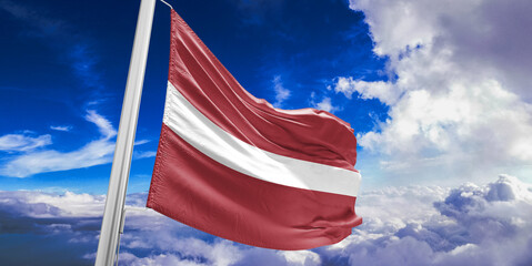 Latvia national flag cloth fabric waving on beautiful Blue Sky Background.