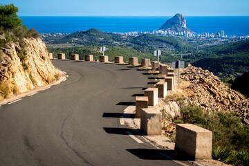 Scenic view of a road built on the edge of a mountain with a beautiful view of a city in the back