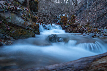 long exposure, a stream among the stones, water grinds a stone, a mountain stream