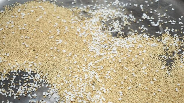 Closeup of popping amaranth seeds in a metal pot