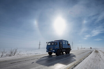 A truck on a winter road with a halo background