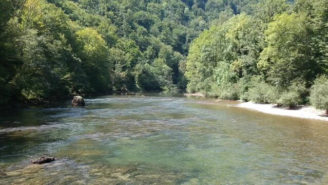 View of the river in a green valley among a dense forest. Beautiful landscape of the Kolpa, Slovenia