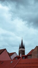 Obraz premium Beautiful view of an old tower and rooftops under the cloudy sky